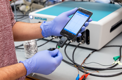 Gloved hands hold the RAPID 1.0 diagnostic, a low-cost COVID-19 test can detect SARS-CoV-2 within four minutes with 90 percent accuracy.